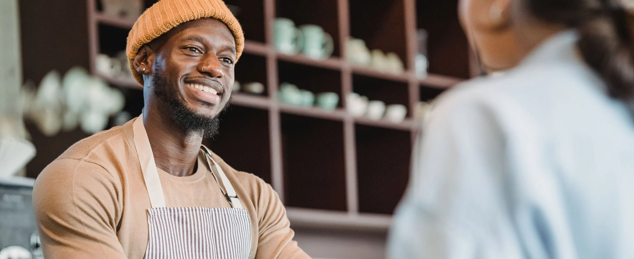 A café worker talking with a customer at the counter